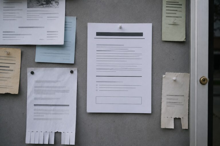 A single official-looking public WARN notice pinned to a government bulletin board among overlooked papers, the kind of public layoff filing anyone can check.